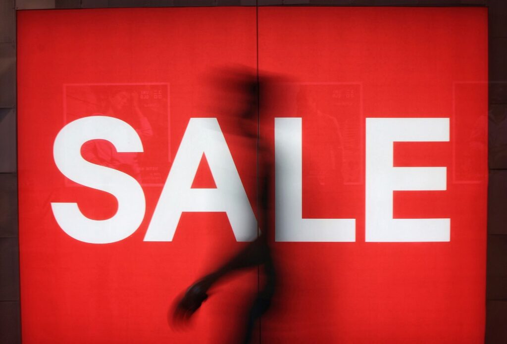 shows a large sale sign on a red background - Clothing brand description examples