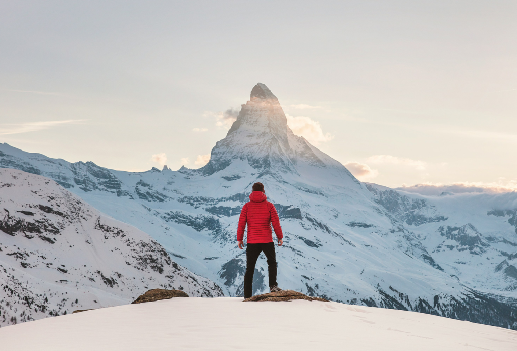 shows a man standing in front of a mountain - how to write a travel blog post 