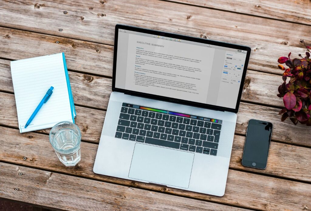 shows a mac book on a wooden table - blog copywriting guide