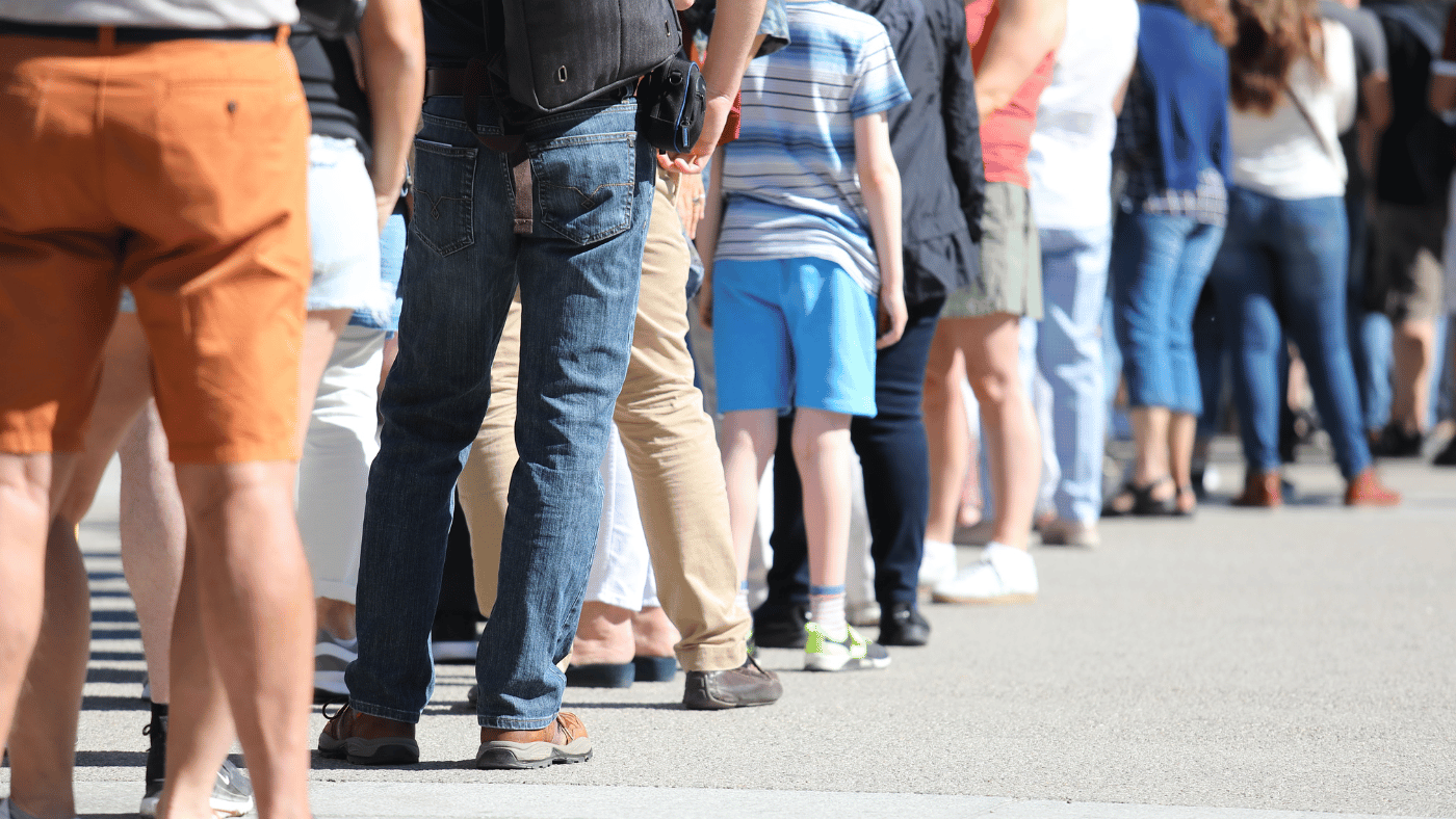 Shows a group of people standing in a line