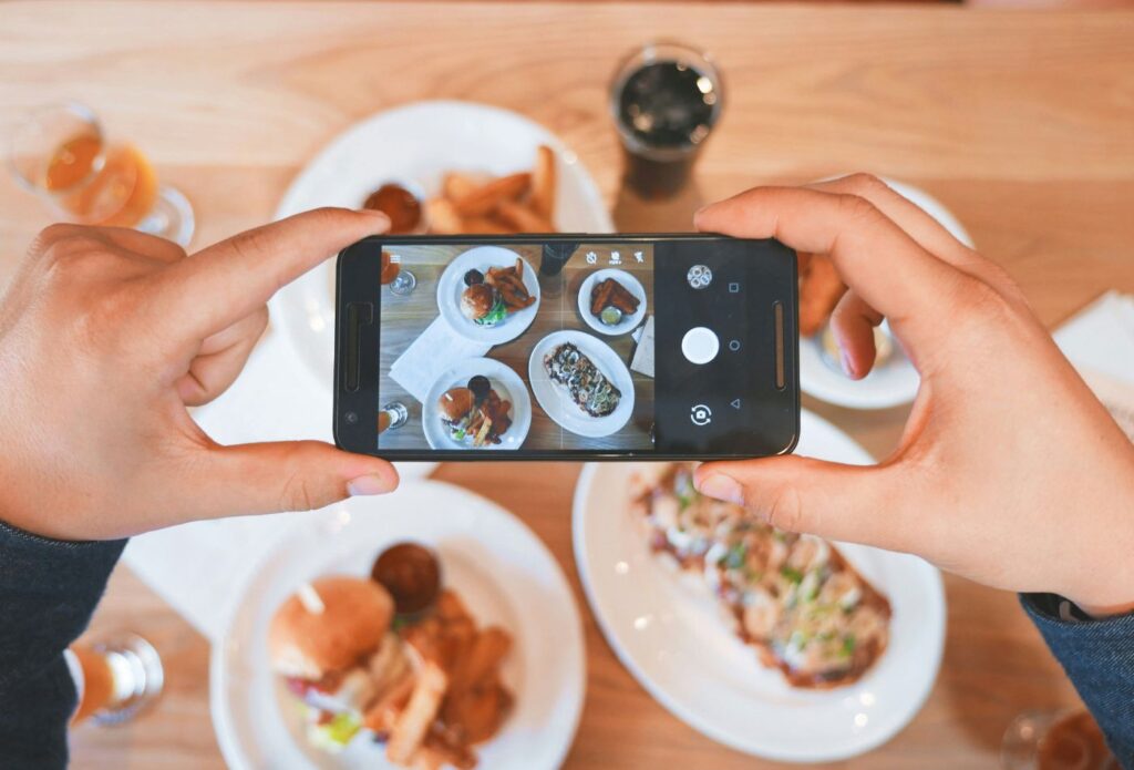 Shows a food copywriting expert taking a photo of food