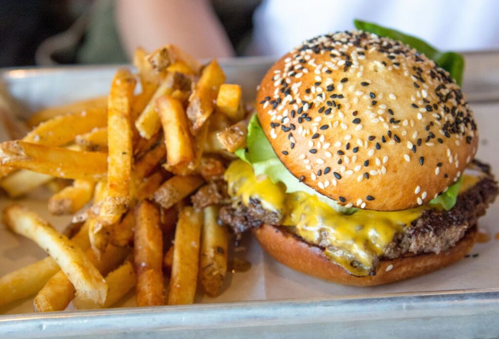 Shows a juicy burger and fries dish - Food content writing examples