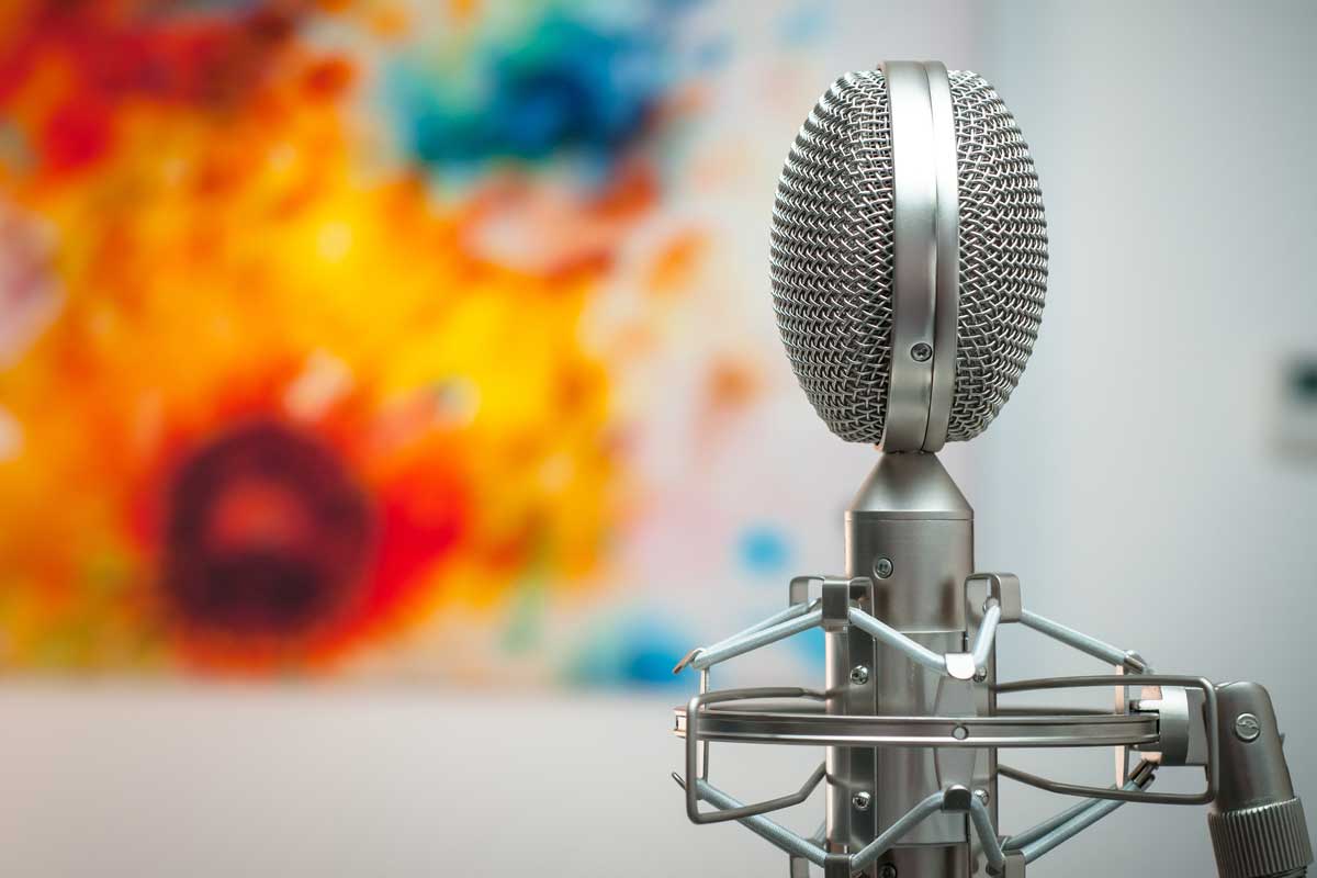 How to create brand tone of voice guidelines - Shows a microphone with a colourful background