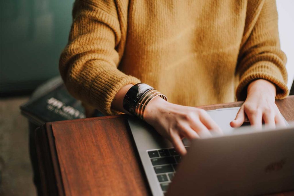 Writing copy for new websites - Shows a woman typing on a laptop