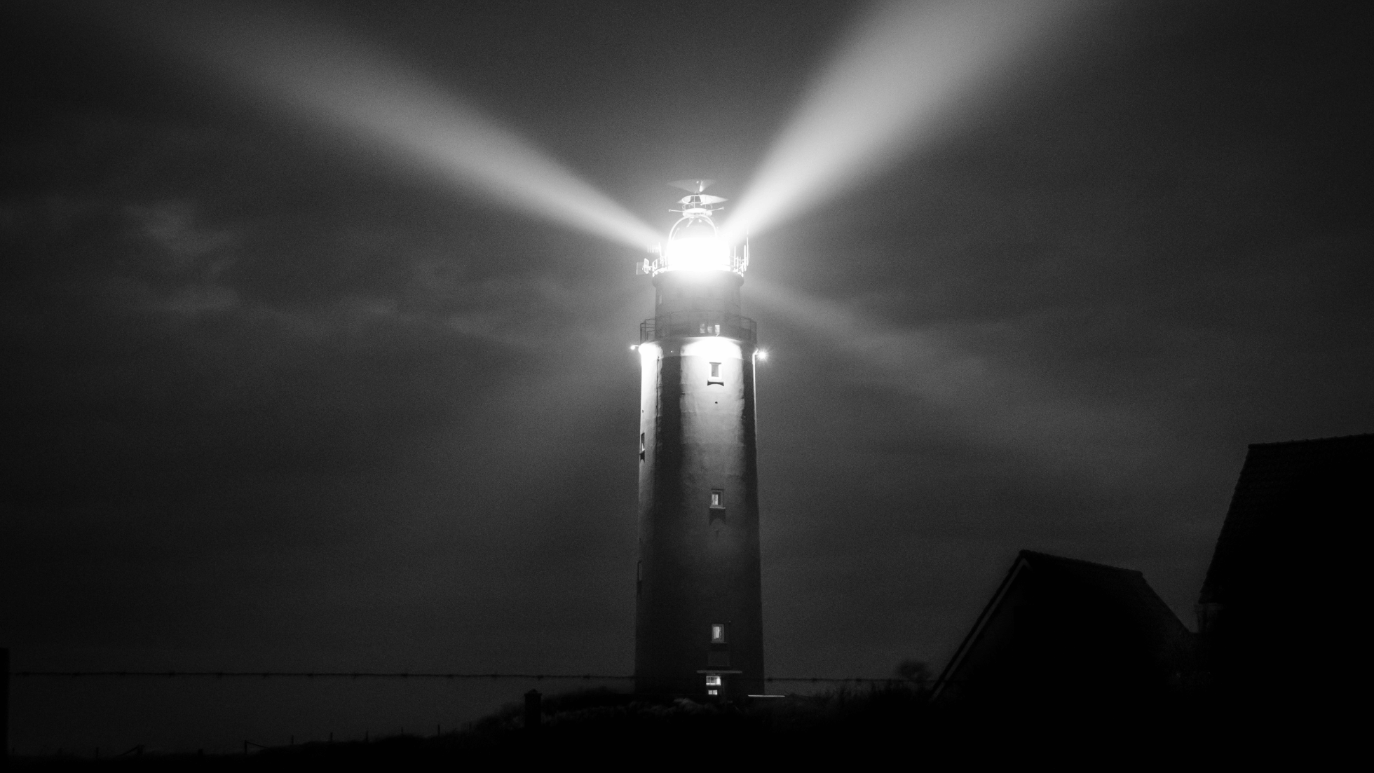 Shows a lighthouse at night