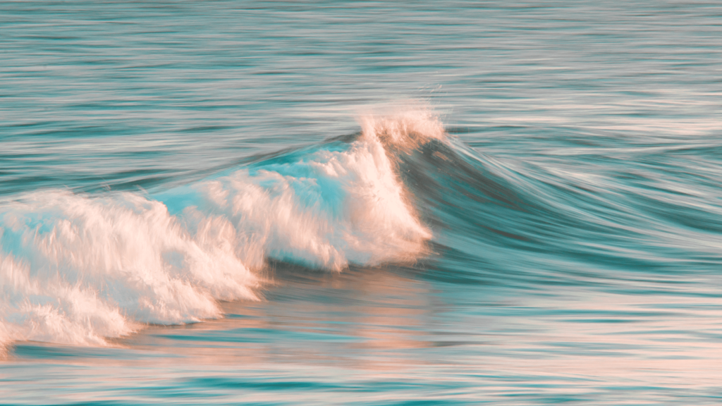 Shows a crashing wave by the beach