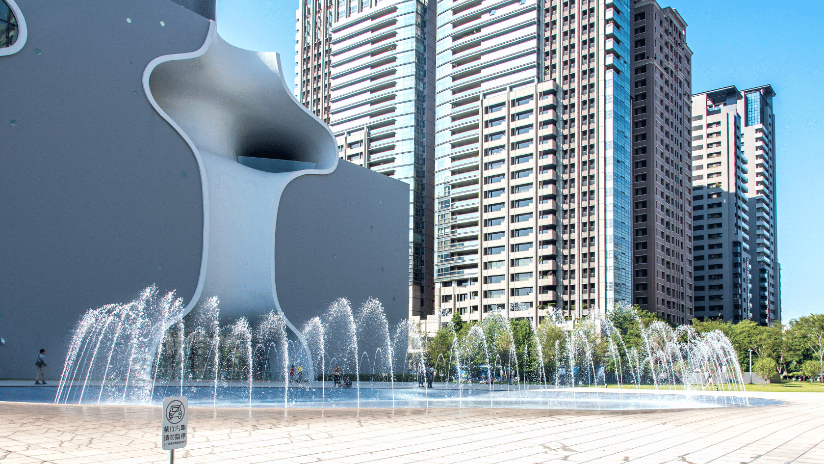 A fountain beside a row of skyscrapers
