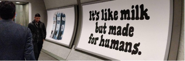 shows a person walking next to a billboard in the underground - food description examples