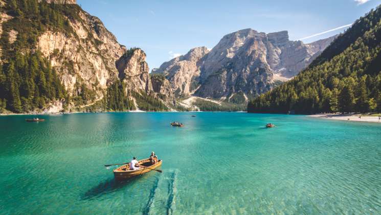 shows an image of people in boats next to limestone cliffs