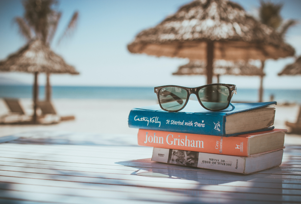 Travel article examples - Shows a stack of books on a beach