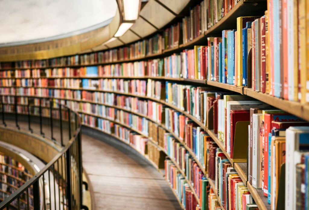 shows different books on a shelf in a library 