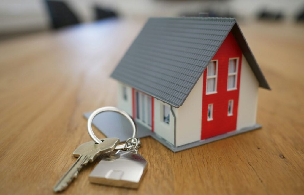shows a small house keyring on a wooden table 
