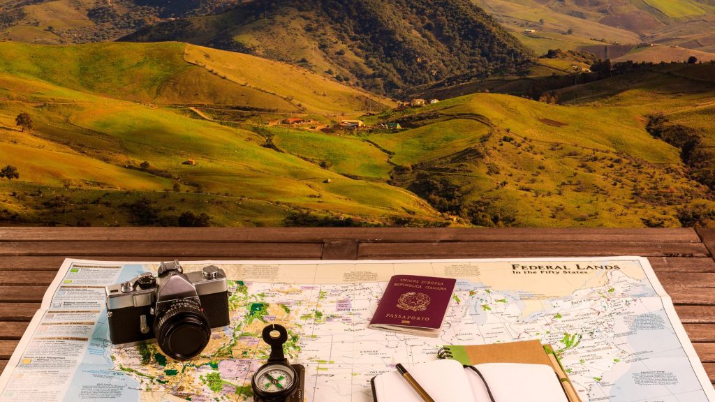 Shows a selection of travel planning accessories on a desk