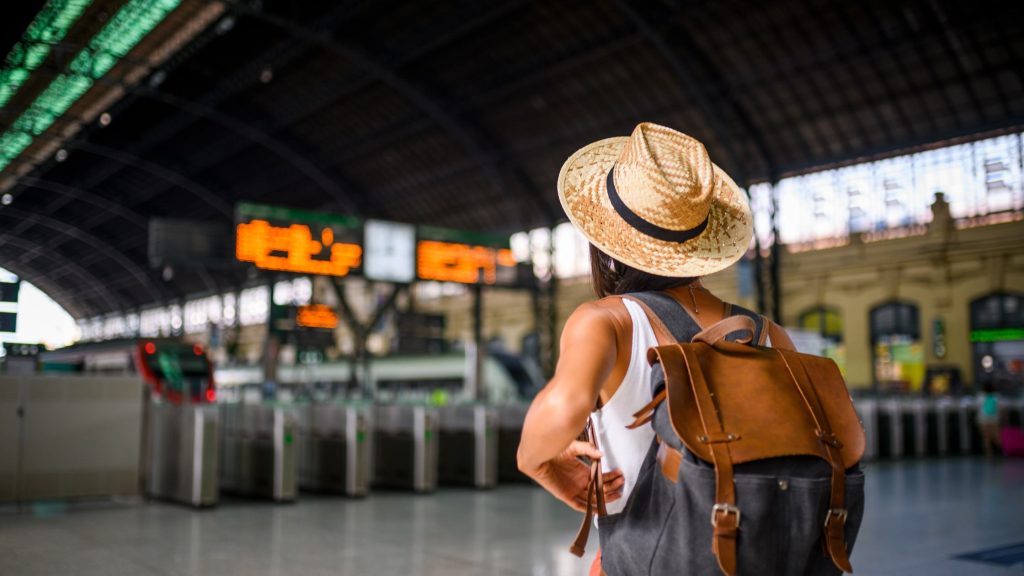 Shows a traveller at the train station
