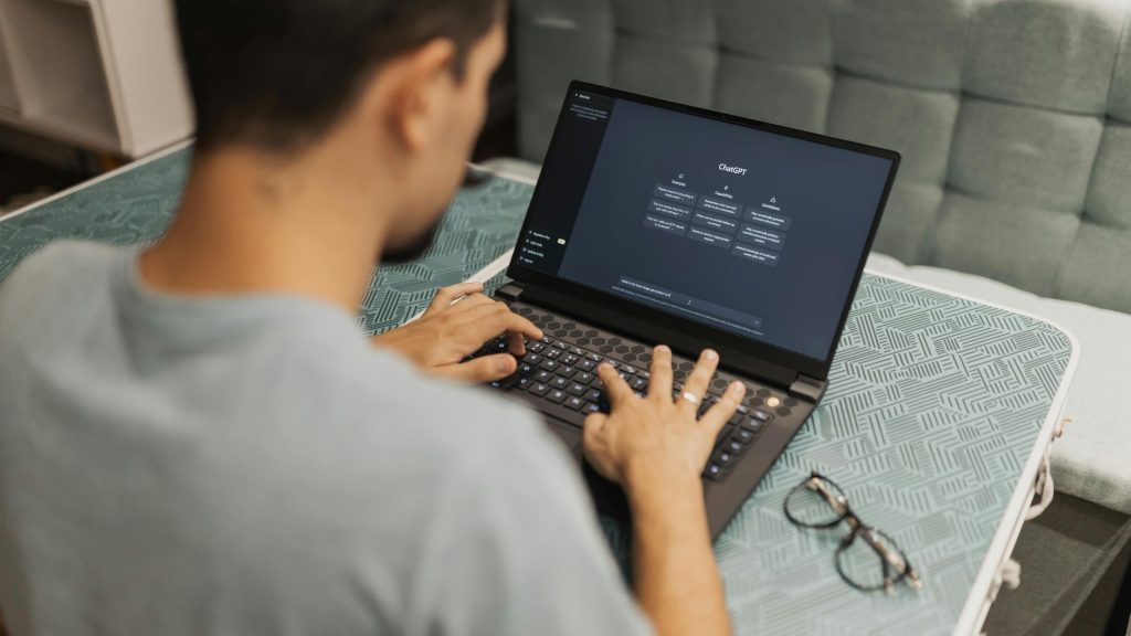 Shows a man on Chat GPT on a laptop