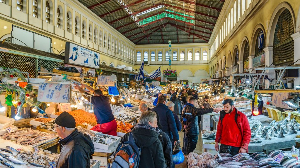 shows people in a fresh food market in Greece
